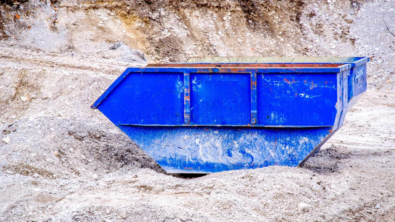 a blue dumpster on a construction jobsite